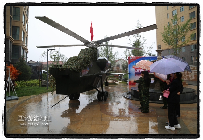 小區(qū)突然出現(xiàn)“飛機坦克”，其中殲15艦載戰(zhàn)斗機一架、99式主戰(zhàn)坦克一輛、武直-10武裝直升機一架，吸引了眾多市民雨中圍觀、合影。